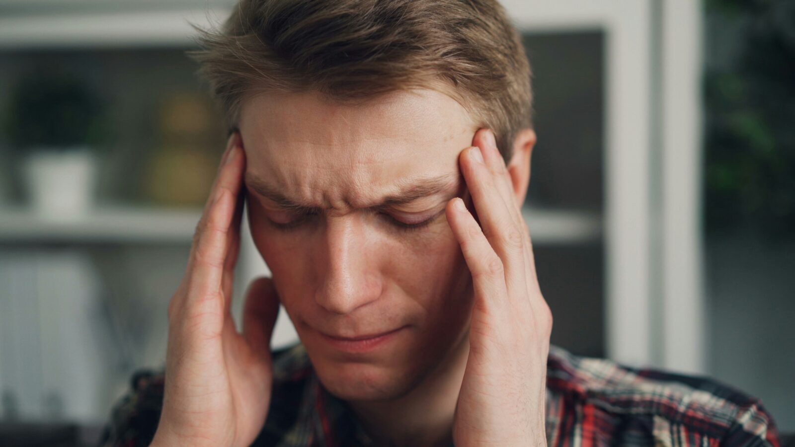 Person holding temples in pain, representing the need for migraine treatment Fairfax patients seek