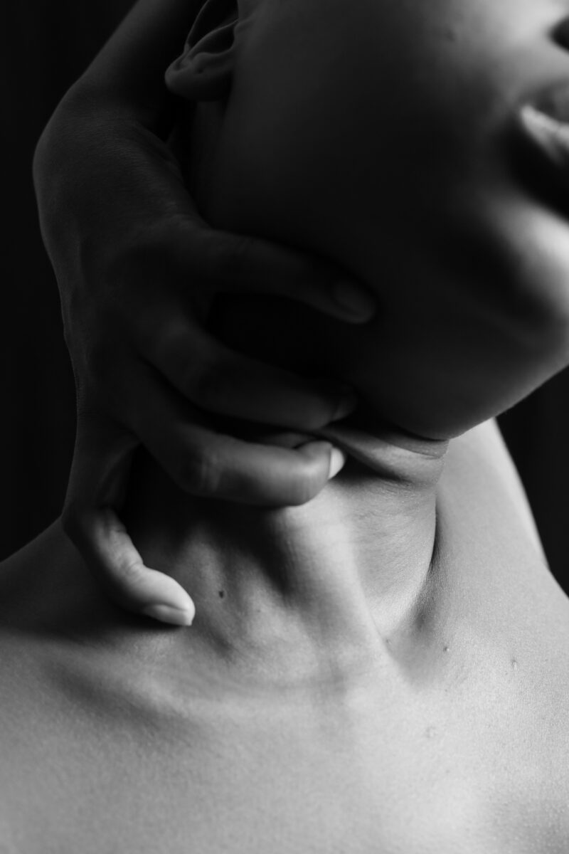 Hands gently examining the thyroid gland area, representing hyperthyroidism care in Fairfax